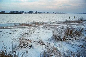 People walk across ice rink, frozen Elbe