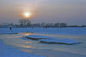 People walk across ice rink, sunset