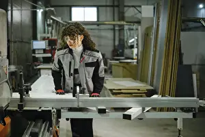 A person stands at a workbench in a workshop