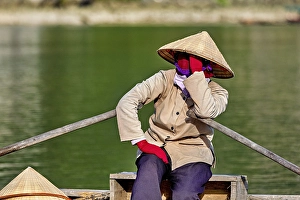 Person in traditional clothes relaxing on a boat on the river
