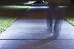 Person Walking on a Illuminated Walkway at Night in Long Exposure in Switzerland