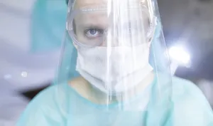 Person wearing a medical mask and face shield