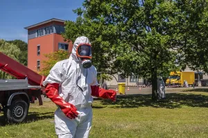 Pest controller in protective suit during oak processionary moth operation