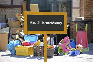 (Photomontage) Sign with the inscription HAUSHALTSAUFLOSUNG in front of bulky waste at a residential building