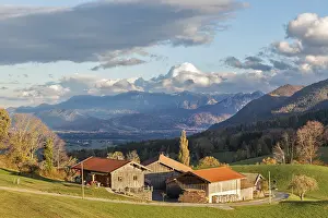 A picturesque farm in front of a mountain backdrop in autumn light