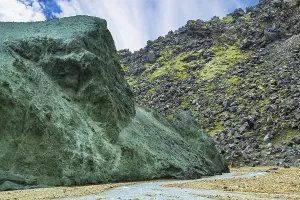 Picturesque huge stone covered with green moss