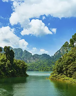 A picturesque lake nestled between forested mountains under a bright sky