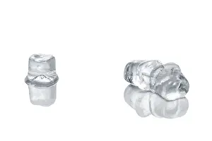 Piece of ice cubes melting on white glass table