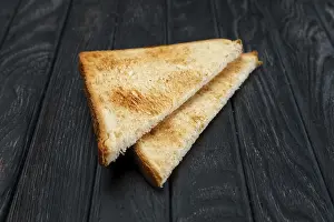 Two pieces of toast bread on dark wooden table