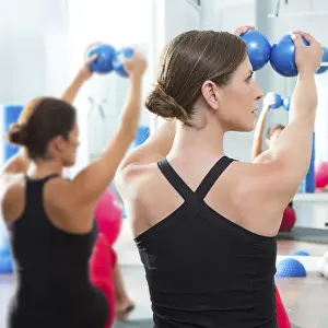 Pilates toning ball in women fitness class rear mirror view