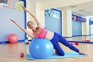 Category Historic EN Prints: Pilates woman side bend fitball exercise workout at gym indoor swiss ball