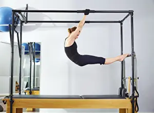 Category Oldtimer Prints: Pilates woman in cadillac acrobatic reformer exercise at gym