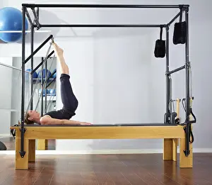 Category Oldtimer Prints: Pilates woman in reformer tower exercise at gym indoor