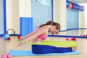 Category Historic EN Prints: Pilates woman rowing rubber band exercise workout at gym indoor