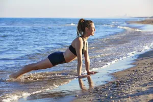 Pilates yoga workout exercise outdoor on the beach sand