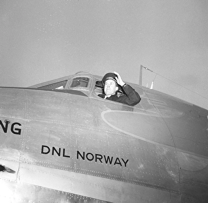 A pilot has opened the window of the cockpit of a DC3 passenger plane, looking out before take-off. The aircraft belongs to the Norwegian airline DNL Det Norske Luftfartselskap. It was Norway's national airline between 1938-1948