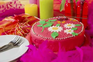 Pink birthday cake with flowers and butterflies in still life