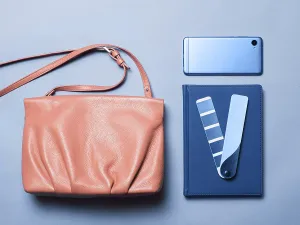Pink coral female leather bag with accessories in classic blue 2020 color over blue background