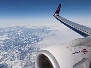 Category Scandinavia Prints: Plane of the Norwegian Airlines flying over the snow-covered Kiruna