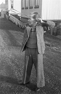 Playing in the 1940s. A boy with a slingshot