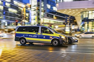 Police car in front of modern architecture of the city centre in the evening