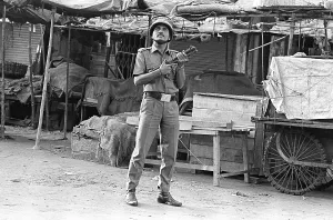 Police constable looking out for rioters near Mohammed Ali road to prevent rioting after religious fundamentalists demolished the Babri Masjid in Ayodhya on 6/12/ 1992. The rioting continued till January 1993 in Bombay Mumbai, Maharashtra, india