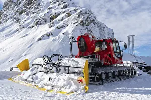 Ponte di Legno, Italy - 03.12.2023: Close-up view of red snow groomer on snowy mountain ski resort