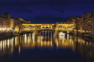 Ponte Vecchio and the buildings close by at night reflecting on the river Arno