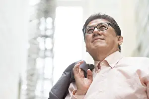 Portrait of 60s Asian Chinese CEO boss smiling and looking away
