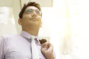 Portrait of Asian Indian business man standing outside modern office building block
