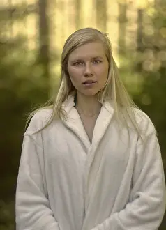 Portrait of beautiful woman in bathrobe outside in nature