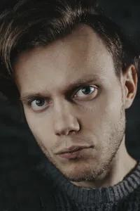 Portrait close-up of a man with captivating eyes against a dark backdrop