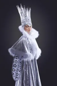 Portrait of serious girl stand in ice queen carnival costume