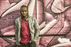 Portrait of a hot black man in front of graffiti wall