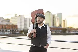 Portrait of a musician looking away while holding his guitar on his shoulder