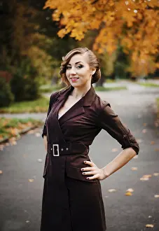 Portrait of smart girl with old-fashioned hairstyle outdoor in brown coat on autumn