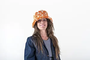 Portrait of a smiling woman wearing a hat and looking at camera over a white background