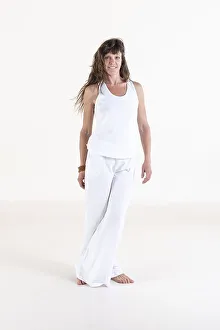 Portrait of a woman dressed in white yoga clothes over white background looking at camera