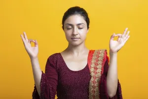 Portrait of young adult indian woman in sari meditate zen like with ok sign mudra gesture