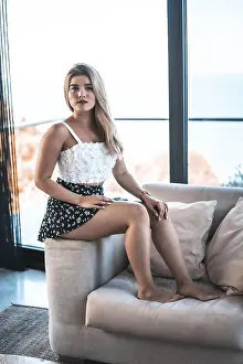 Portrait of a young blonde woman sitting on the couch at home