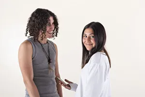 Portrait of a young couple dressed in yoga clothes laughing over white background