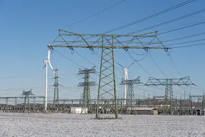 Power pylons, wind turbines, icy field