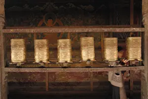 Prayer wheels and a Tibetan pilgrim in Jokhang Temple