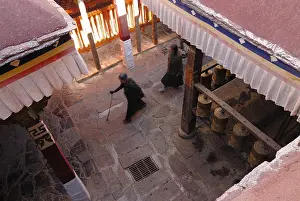 Prayer wheels and Tibetan pilgrims near the Kora