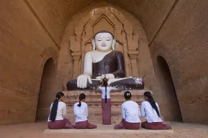 Praying believers in front of Buddha statue