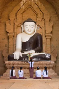 Praying believers in front of Buddha statue