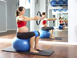 Pregnant woman pilates exercise magic ring with fitball
