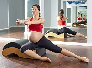 Pregnant woman pilates side stretchs exercise with Wave corrector