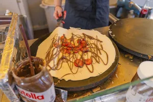 Preparation of a crepe with Nutella and strawberries in a lively kitchen