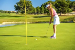 Professional golfer putting the ball on a sunny day